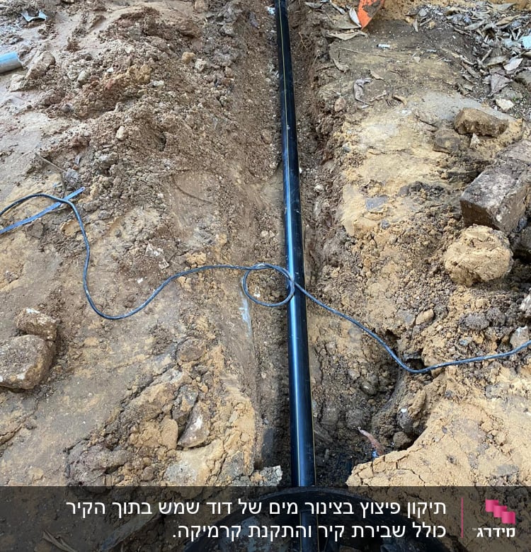 צינור שחור בתעלה באדמה עם את חפירה כתום